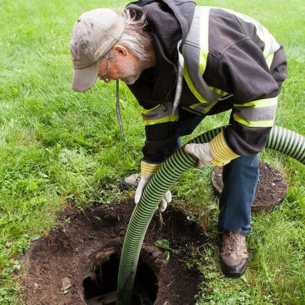 A septic tank being pumped out through the access lid