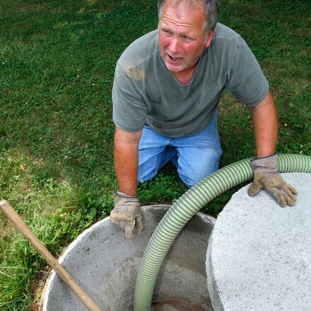 A homeowner watching their septic tank being pumped